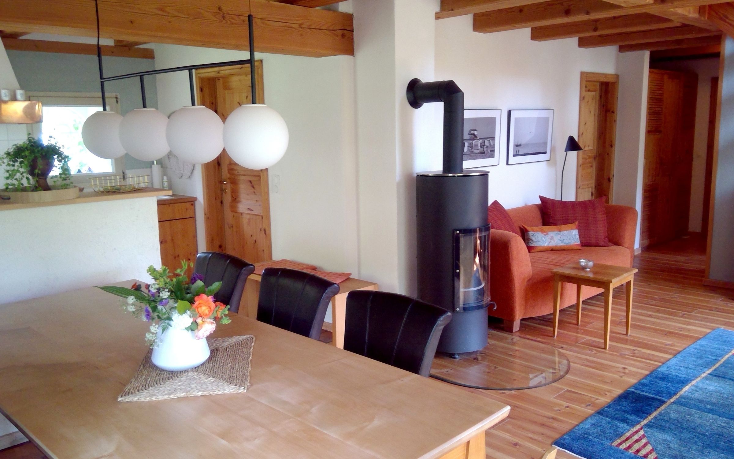 Heller Wohn-/Essbereich mit großem Tisch und Kaminofen im Ferienhaus Achter de Kark.